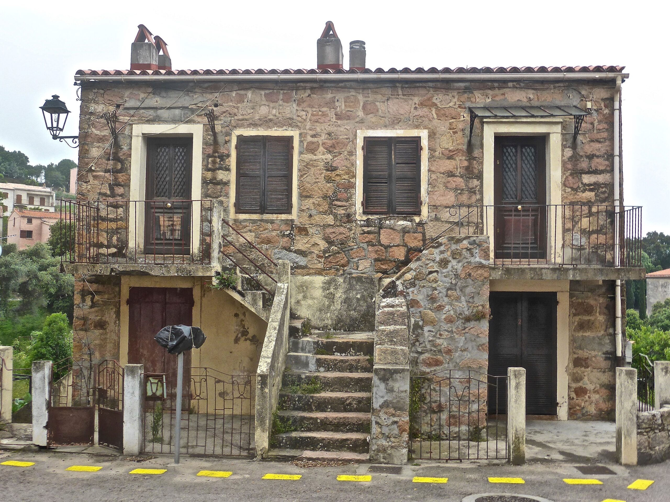 Das Foto zeigt ein älteres Steinhaus, wie es in Südfrankreich üblich ist. Es ist zweigeschossig und hat eine Steintreppe, die in die erste Etage führt